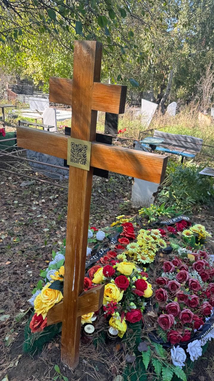 Золотистая табличка с QR‑кодом на чёрной гранитной стеле
