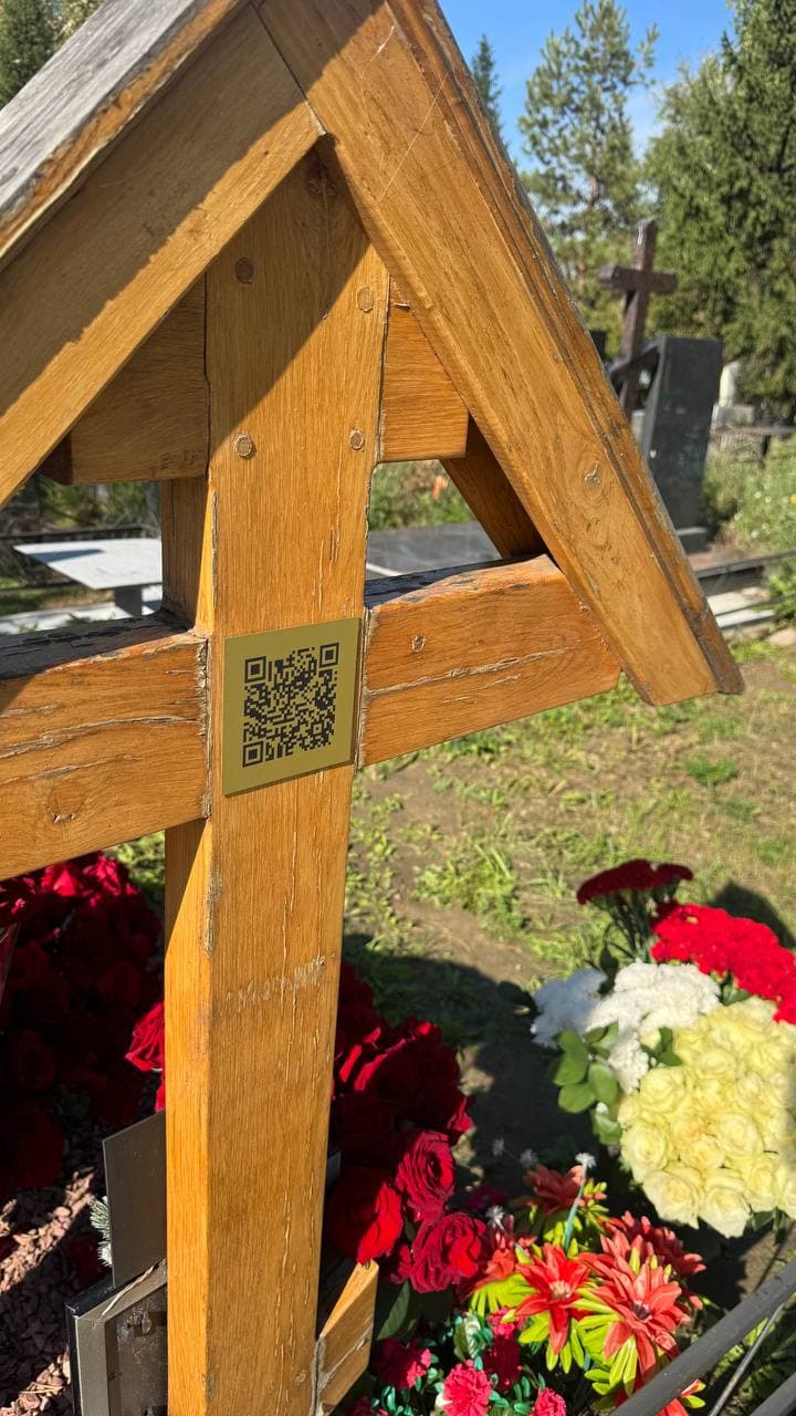 Золотистая табличка с QR‑кодом на деревянном кресте с кровлей